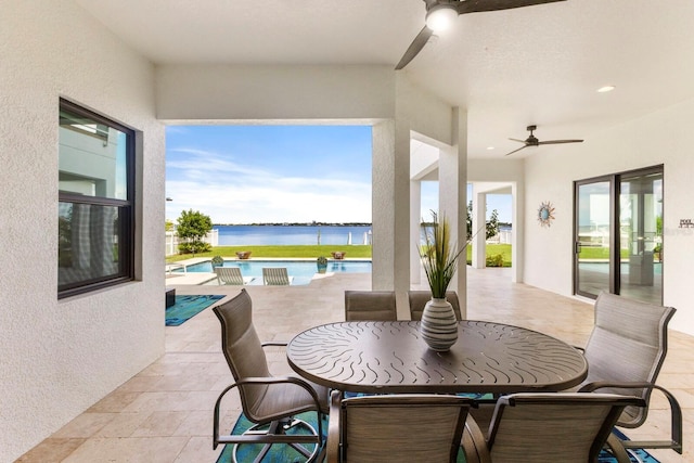 view of patio featuring a water view and ceiling fan