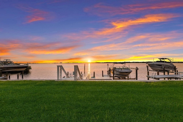 dock area with a water view and a lawn