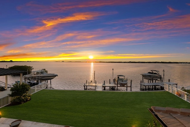 dock area featuring a water view and a lawn