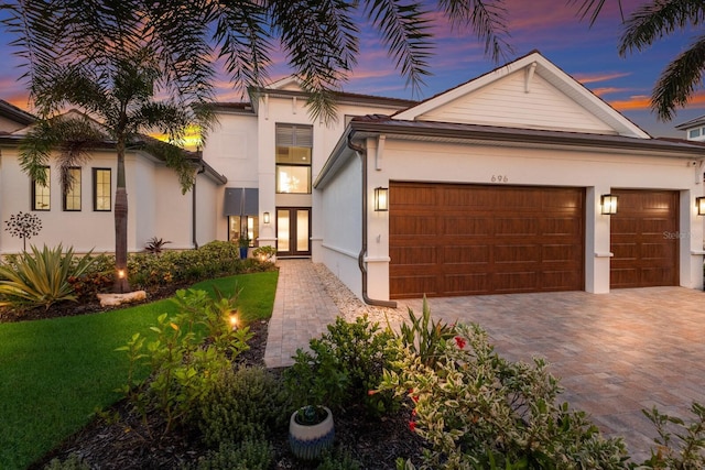 view of front of home with a garage and a yard