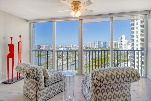 sunroom with ceiling fan, a healthy amount of sunlight, and a water view