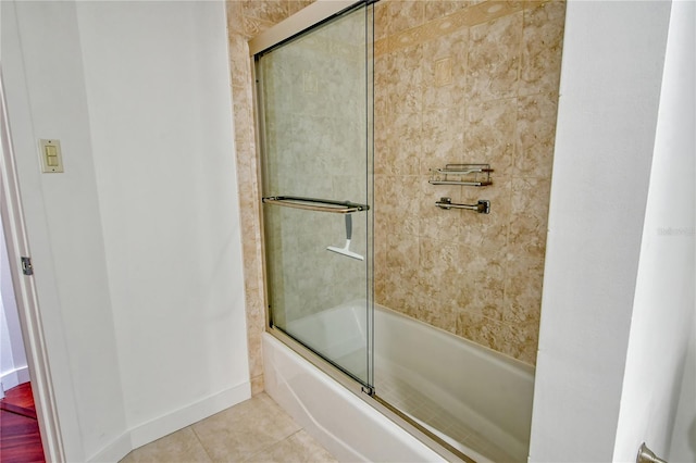 bathroom with bath / shower combo with glass door and tile patterned floors