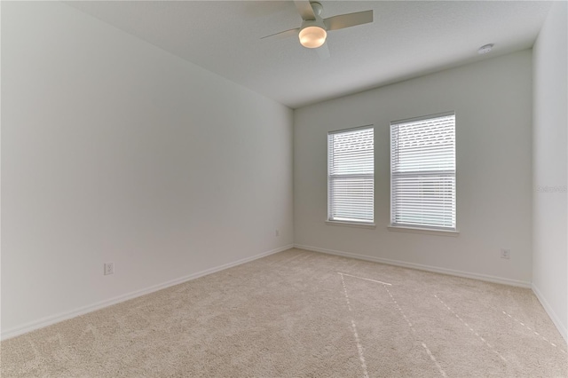 carpeted spare room with ceiling fan