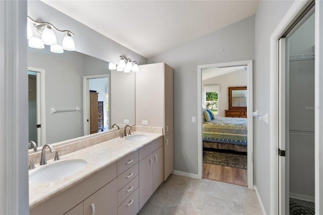 bathroom featuring vanity, vaulted ceiling, and tile patterned floors