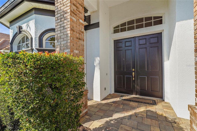 entrance to property featuring stucco siding