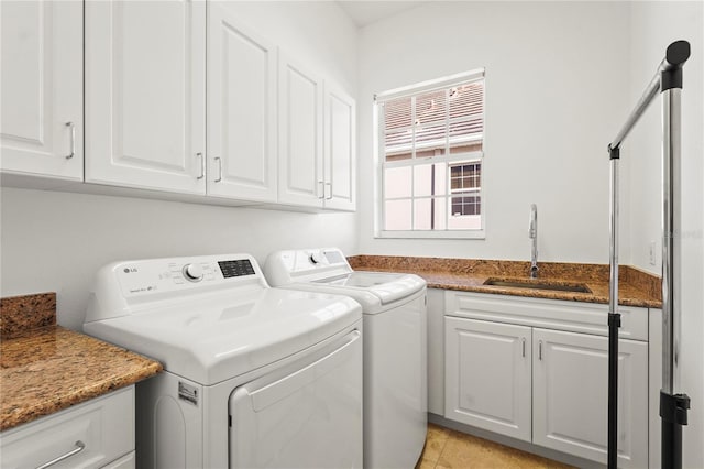 clothes washing area featuring washing machine and clothes dryer, a sink, and cabinet space