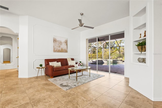 living area featuring built in features, light tile patterned floors, visible vents, a ceiling fan, and a sunroom