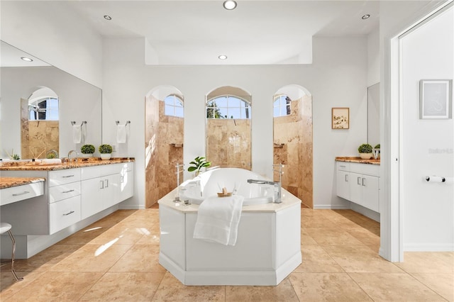 bathroom featuring tile patterned flooring, a garden tub, vanity, and recessed lighting