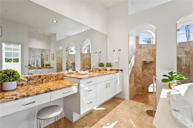 bathroom featuring tile patterned floors, a sink, walk in shower, two vanities, and recessed lighting