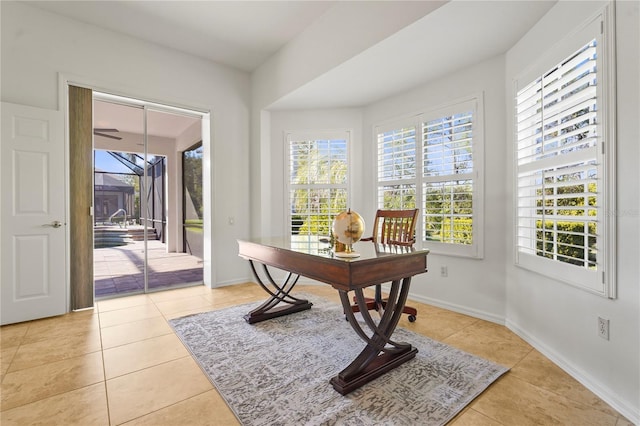 office space featuring light tile patterned flooring, plenty of natural light, and baseboards