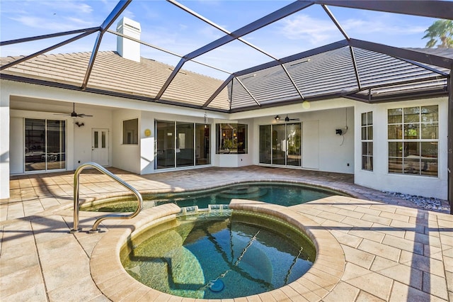 view of swimming pool with ceiling fan, glass enclosure, a patio area, and a pool with connected hot tub