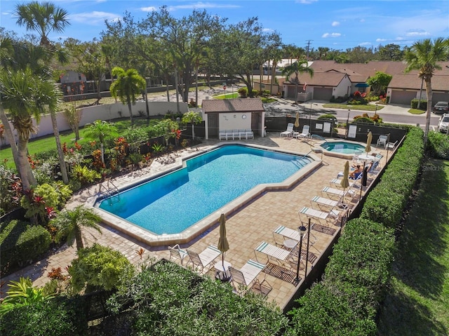 view of swimming pool with a hot tub and a patio area