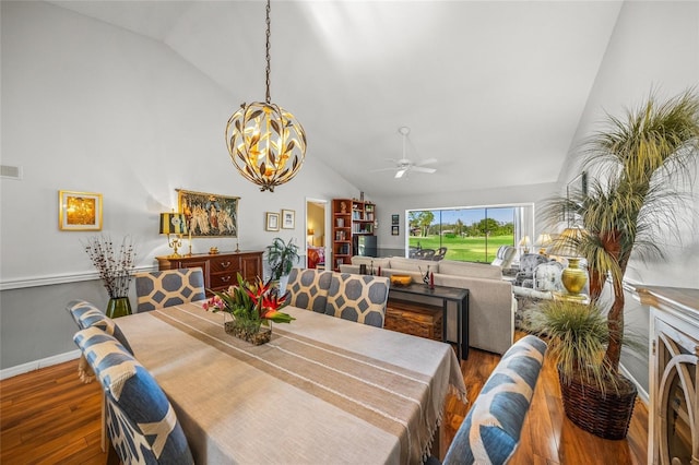 dining area with ceiling fan with notable chandelier, high vaulted ceiling, and hardwood / wood-style floors