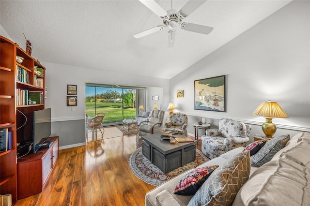 living room with wood-type flooring, lofted ceiling, a textured ceiling, and ceiling fan