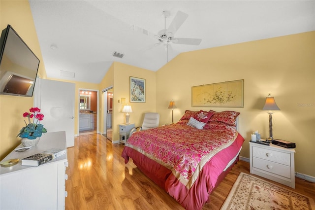 bedroom with hardwood / wood-style floors, ensuite bath, vaulted ceiling, and ceiling fan