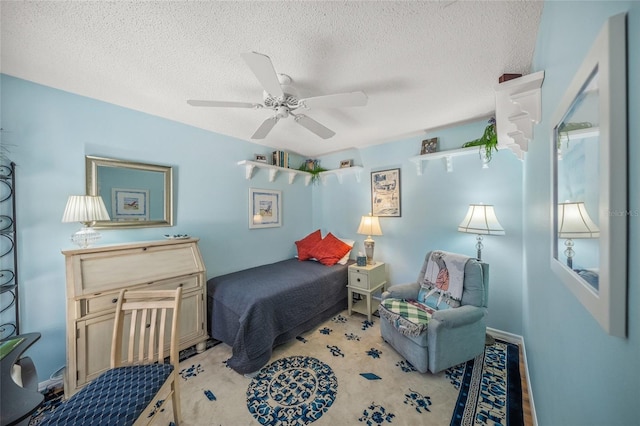 bedroom featuring ceiling fan, a textured ceiling, and carpet flooring