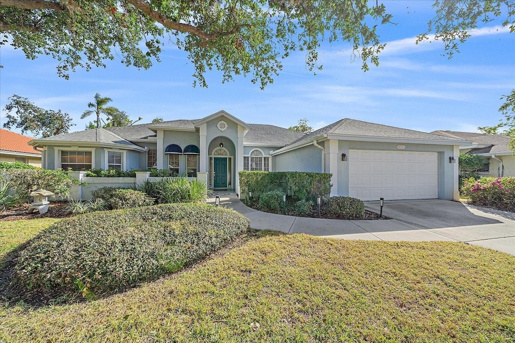 single story home featuring a garage and a front yard