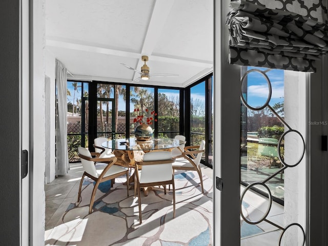 sunroom / solarium featuring beam ceiling, a wealth of natural light, and ceiling fan