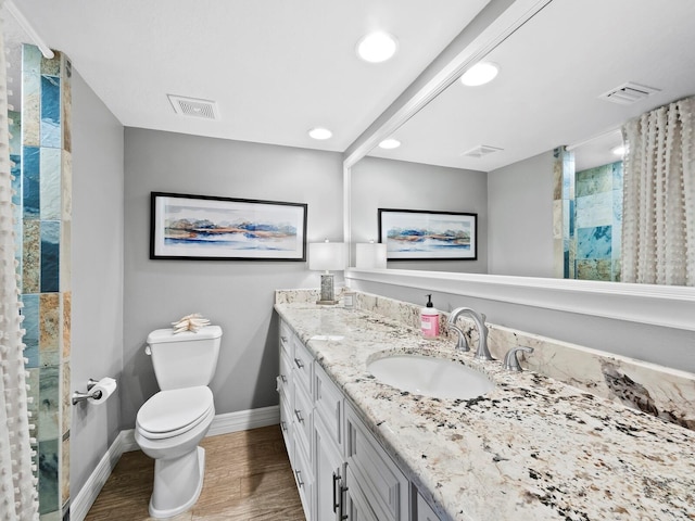 bathroom with wood-type flooring, a shower, vanity, and toilet