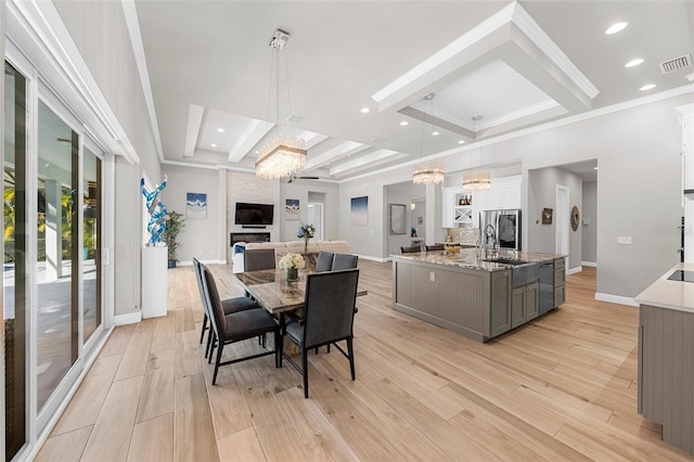 dining room featuring beamed ceiling, coffered ceiling, a notable chandelier, and light hardwood / wood-style floors