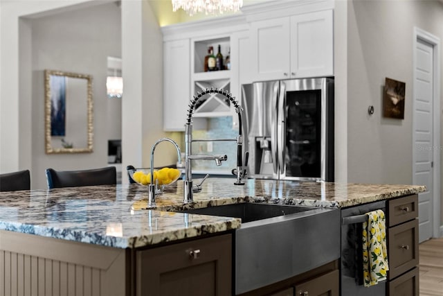 kitchen featuring white cabinetry, stainless steel appliances, sink, and light stone counters