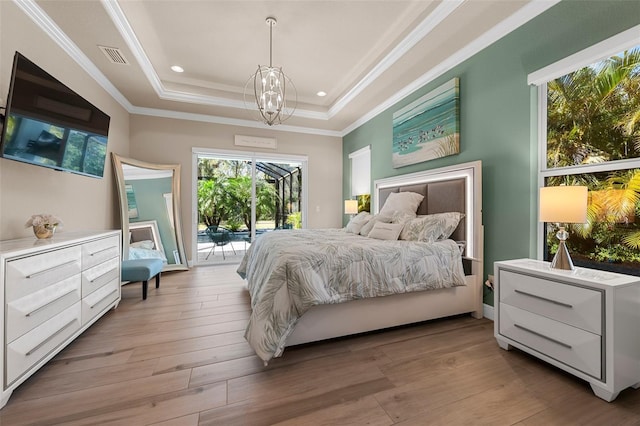 bedroom with crown molding, an inviting chandelier, access to outside, a raised ceiling, and light hardwood / wood-style floors