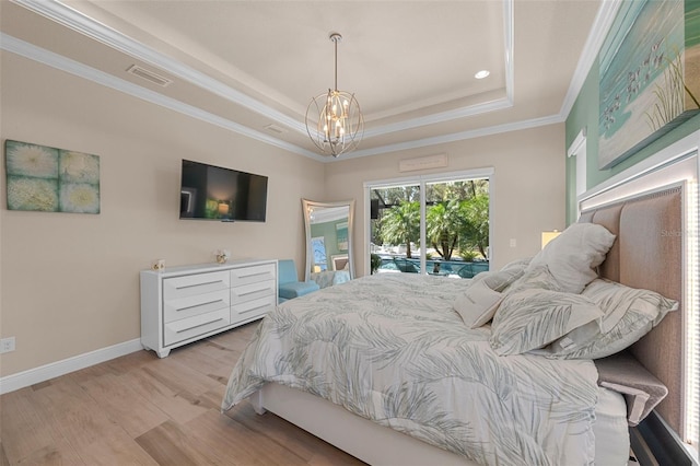 bedroom featuring a chandelier, access to outside, a tray ceiling, crown molding, and light hardwood / wood-style flooring