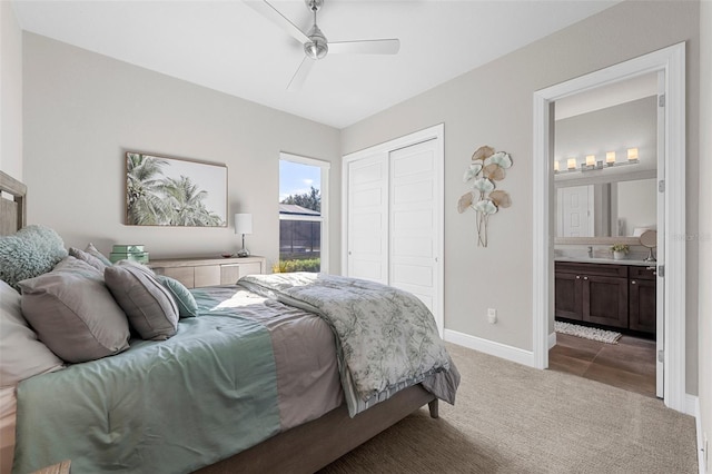 carpeted bedroom with ensuite bath, a closet, and ceiling fan