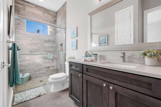 bathroom featuring vanity, toilet, and walk in shower