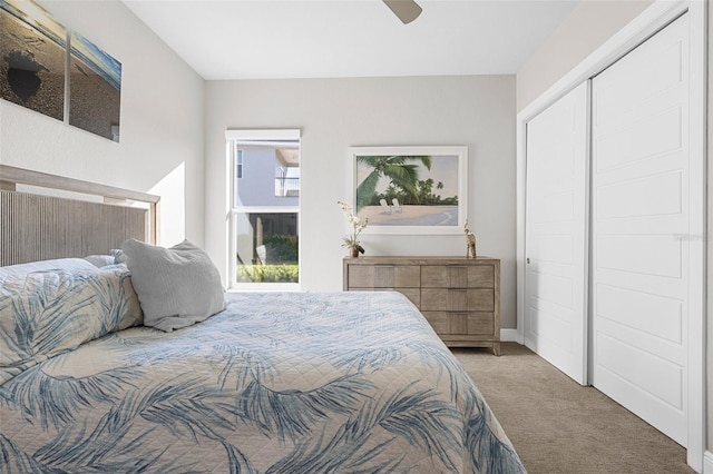 carpeted bedroom with ceiling fan and a closet