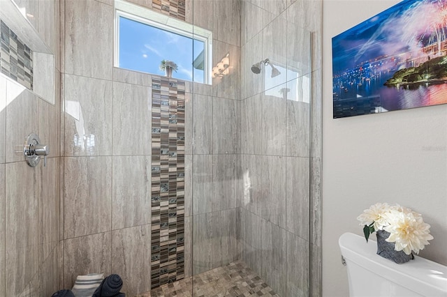 bathroom featuring toilet and tiled shower