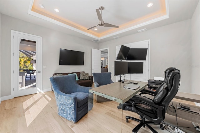 office with light hardwood / wood-style flooring, a raised ceiling, and ceiling fan