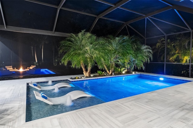 view of swimming pool with a fire pit, a lanai, a patio area, and a hot tub