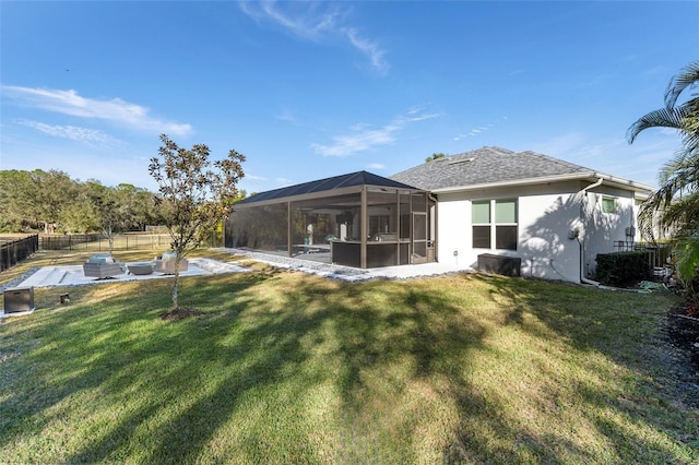 back of house with a lawn, glass enclosure, and a patio area