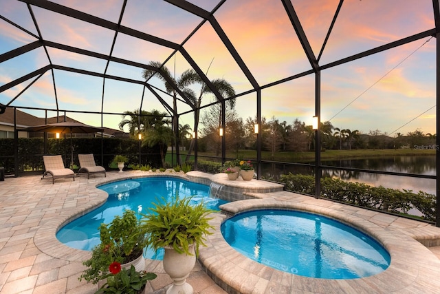 pool at dusk featuring a lanai, a water view, a patio area, a jacuzzi, and pool water feature