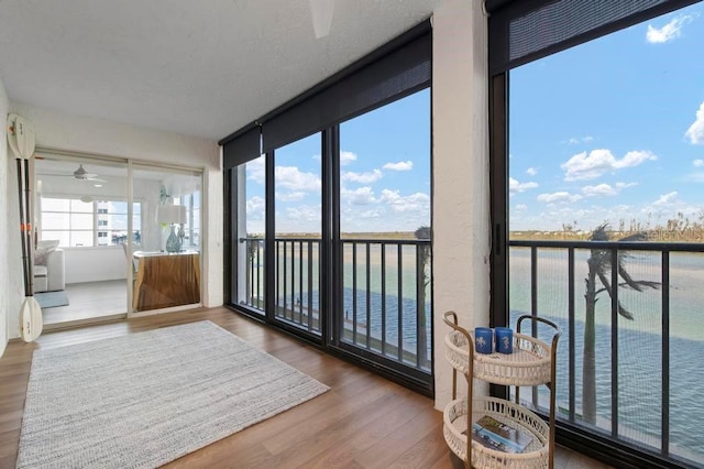 sunroom / solarium featuring a water view and a wealth of natural light