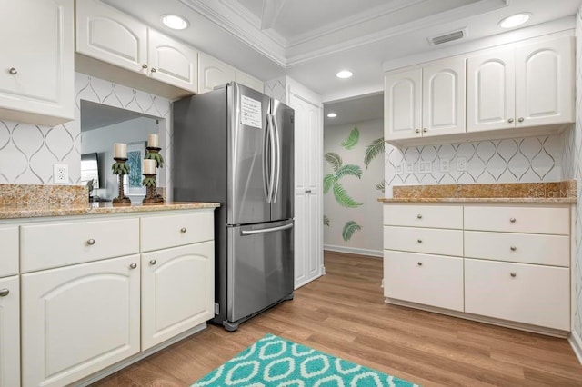 kitchen featuring ornamental molding, stainless steel refrigerator, white cabinets, and light wood-type flooring