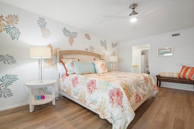 bedroom with ceiling fan, hardwood / wood-style floors, and ensuite bath