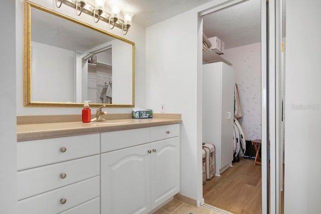 bathroom with vanity, hardwood / wood-style floors, and a textured ceiling