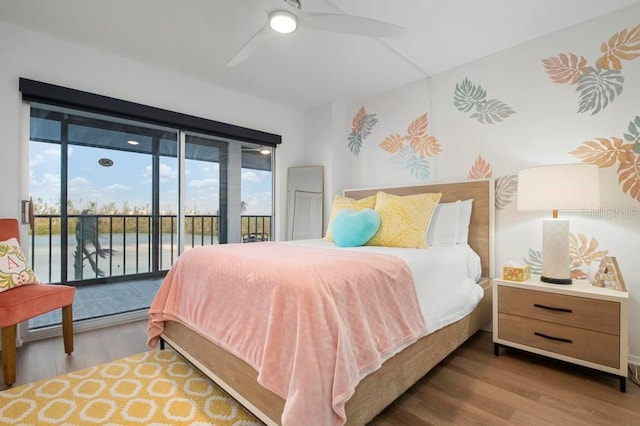 bedroom featuring hardwood / wood-style flooring, access to outside, ceiling fan, and a water view