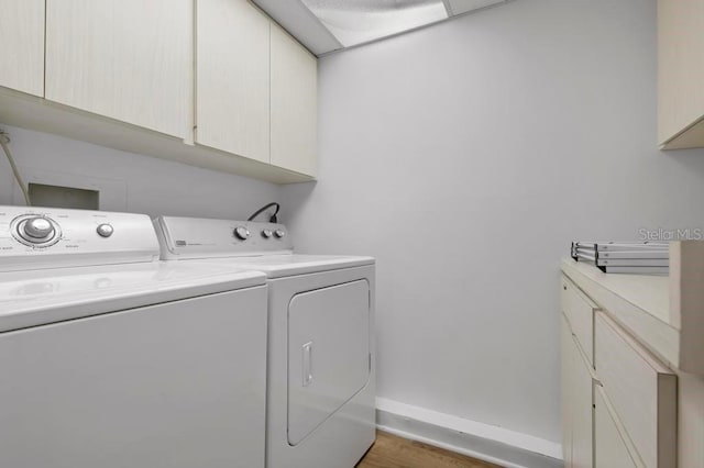 laundry area with cabinets, dark hardwood / wood-style floors, and washer and dryer