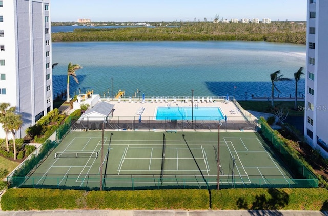 view of tennis court featuring a water view