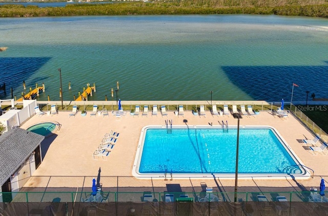 view of swimming pool featuring a patio area and a water view