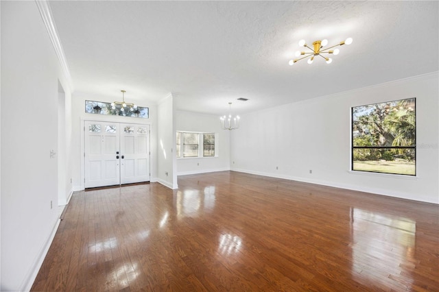 interior space featuring an inviting chandelier, ornamental molding, dark hardwood / wood-style floors, and a textured ceiling