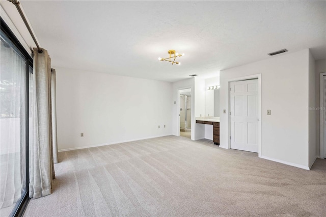 unfurnished bedroom with light colored carpet and ensuite bathroom