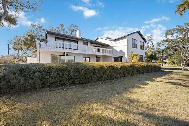 exterior space with a lawn and a balcony