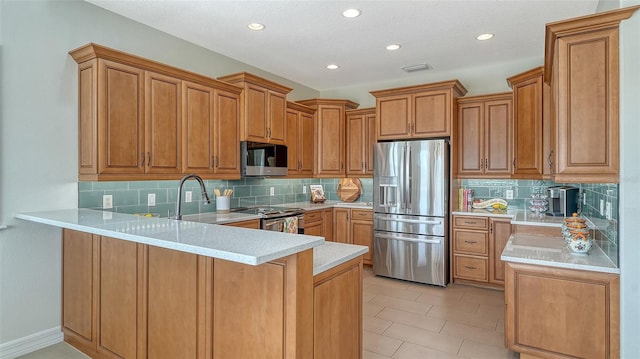 kitchen featuring appliances with stainless steel finishes, kitchen peninsula, and backsplash