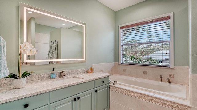 bathroom with vanity and tiled bath