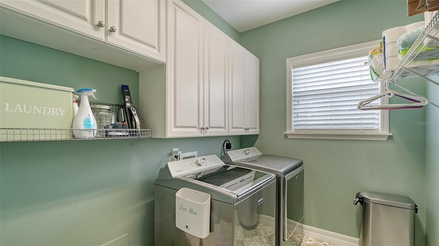 washroom with cabinets and washer and clothes dryer