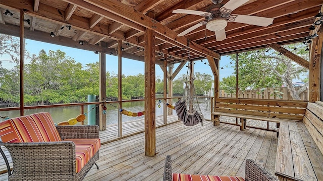 sunroom / solarium featuring ceiling fan and a water view